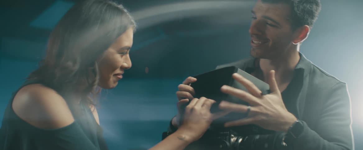 A man and woman adjust a video camera on set