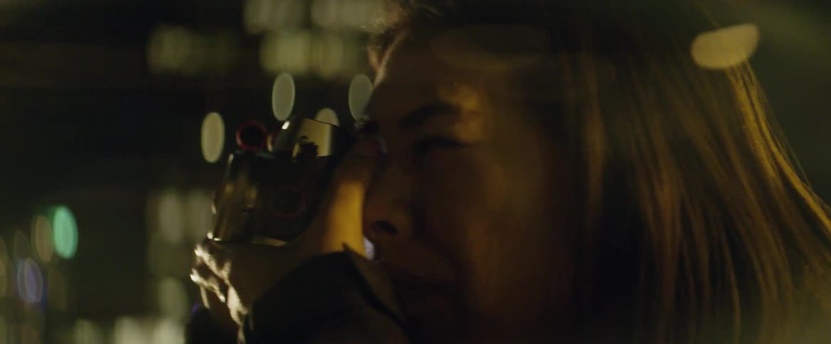 A woman takes a photograph outdoors at night