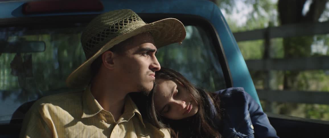 A man and woman embrace each other in the back of a truck