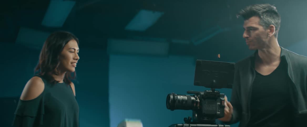 A woman and man are working to set up a camera in a studio