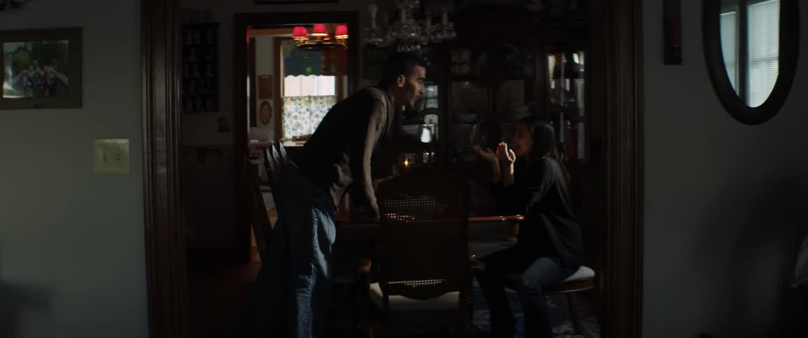 Couple arguing as the man stands up and starts yelling and walking away in a dark room