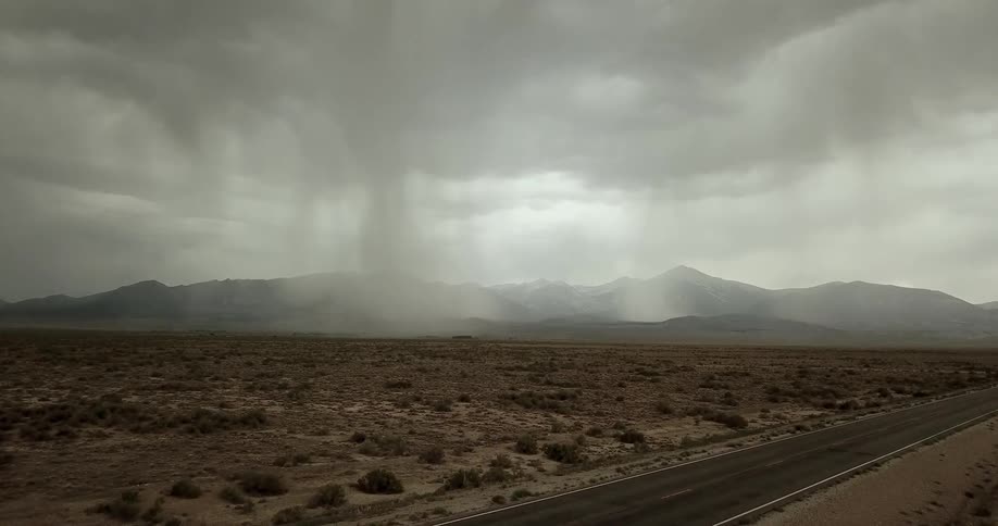 A storm rages by mountains in the desert