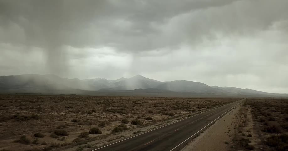 A storm rages by mountains in the desert