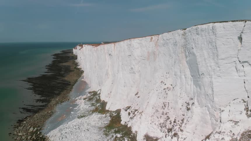 A white cliff stands next to an ocean