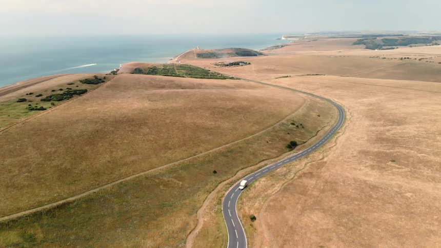 Truck drives on a coastal road on a sunny day