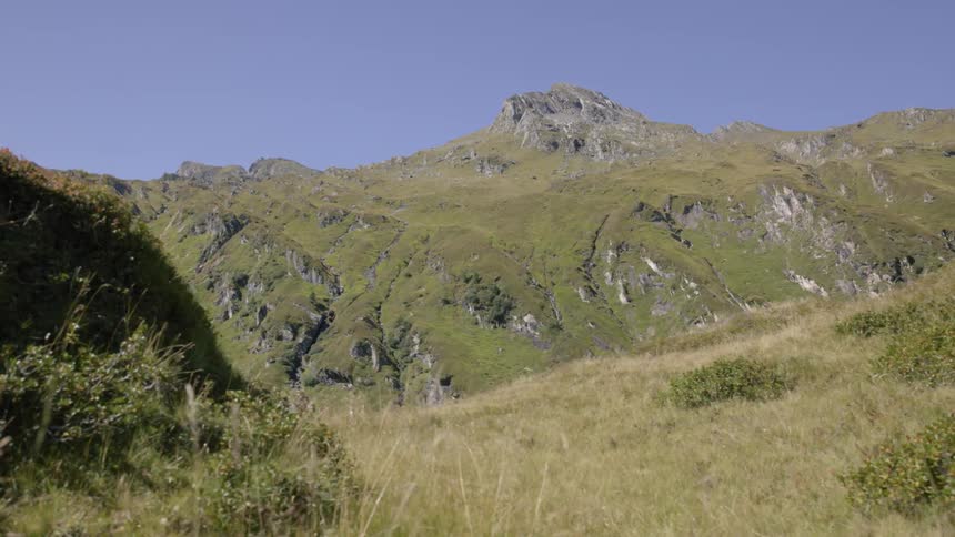A mountaintop overlooks a valley on a clear day
