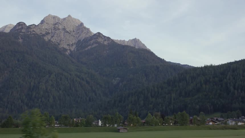 Moving view of mountains from a vehicle driving down a road