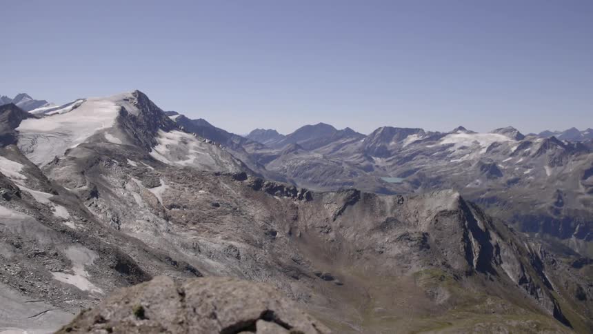 A large mountain range sits below a clear sky