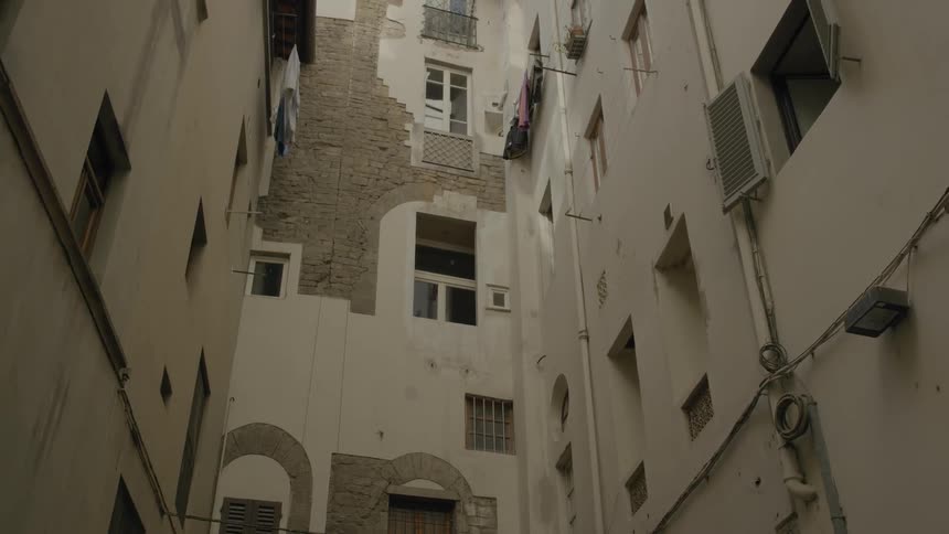 Panning upward view of some buildings and their decay in a city