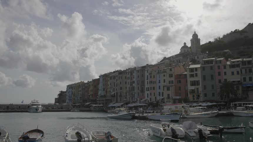 Boats float on water with city buildings in the background