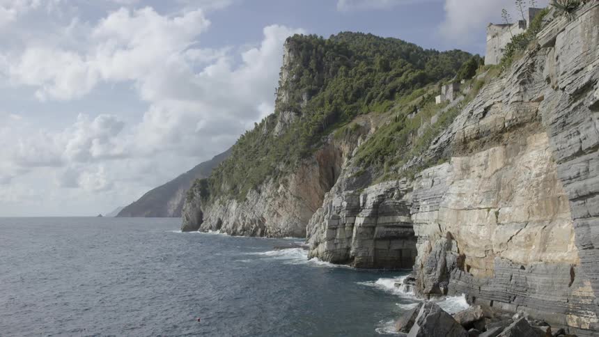 Ocean waves splash against a cliff and cavern