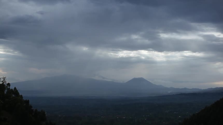 Clouds above a mountainside city in the evening