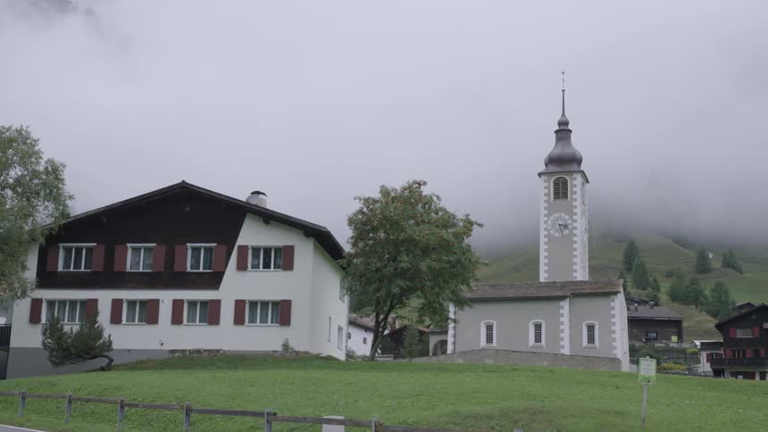 Two-story building next to a church on a cloudy day