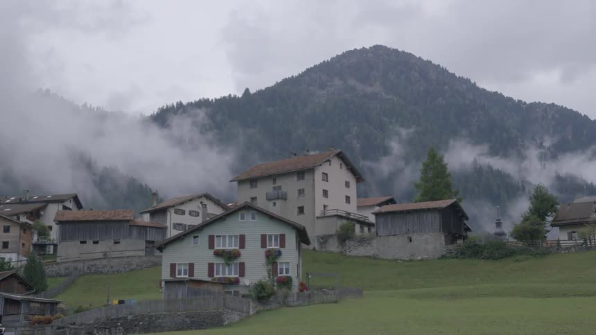 A rock sticking out of a large fog or mist and is barely seen