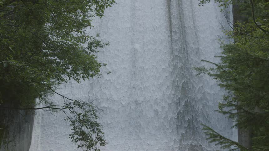 Water falling broadly with foliage in the foreground