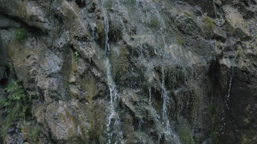 Streams of water flow down a cliff face