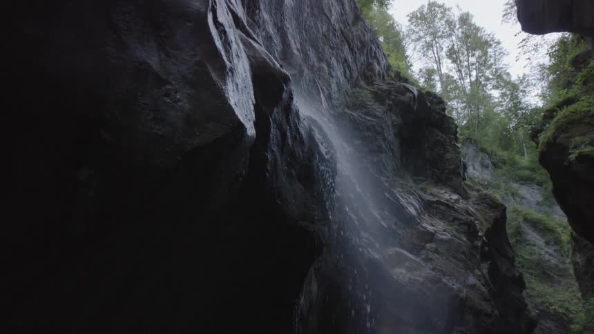 A stream of water is falling down a jagged cliff edge