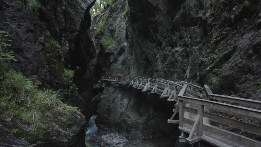 A wooden path runs through a narrow gorge