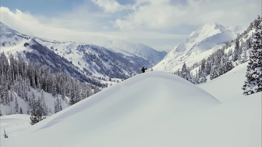 A person hikes in snowy mountains