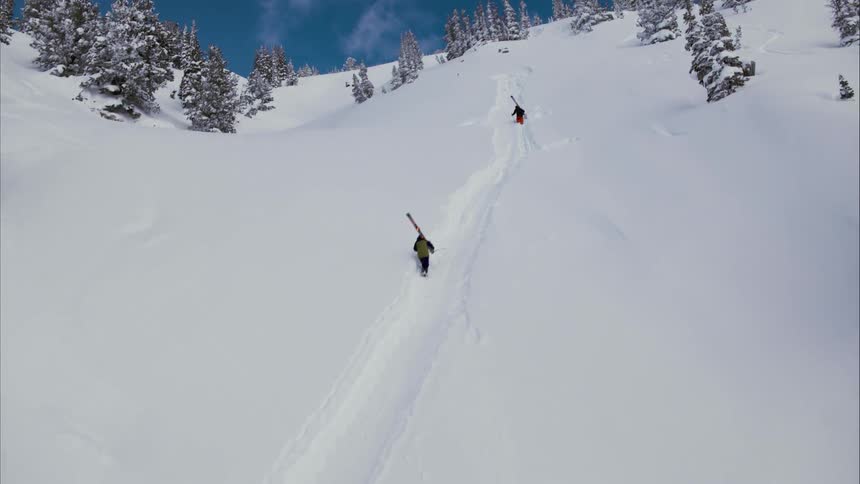 Skiers carry ski's up the slope