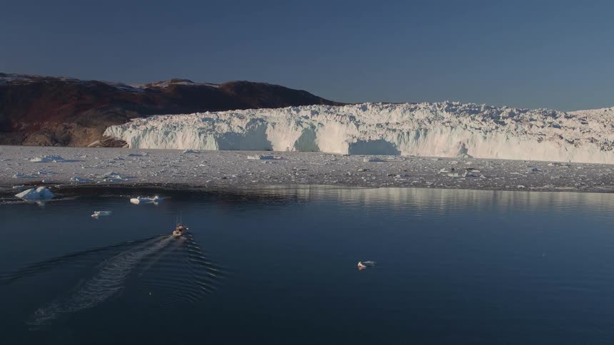 Boat floats on a mountain lake with snow
