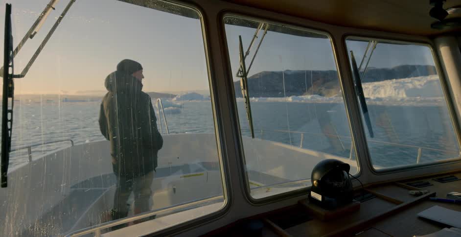 A man stands on the bow of a boat