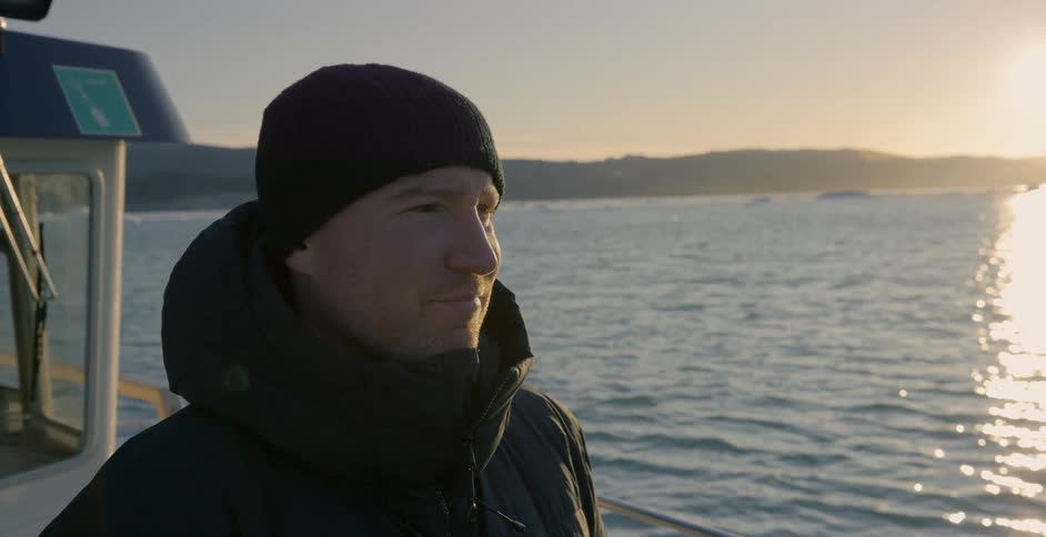 A man stares out the back of a boat