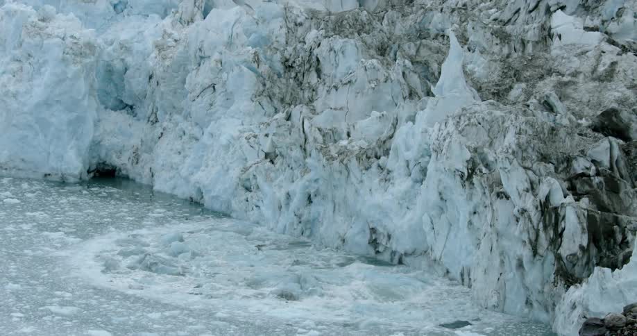 A large ice shelf is collapsing into the icy water below it