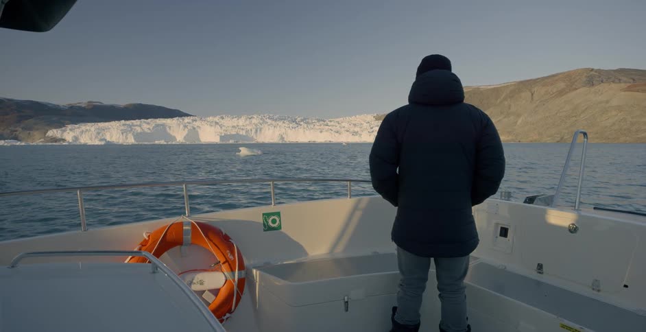 A man on a boat looks at the water