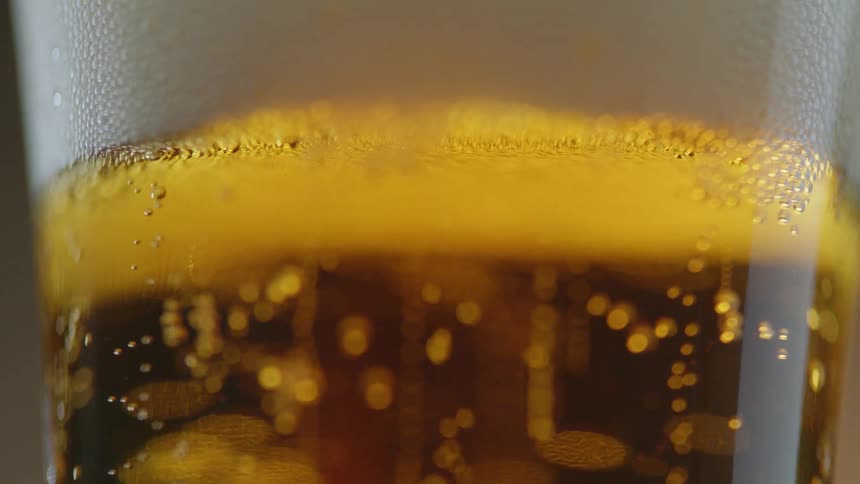 Bubbles rising in a beer and ending with foam
