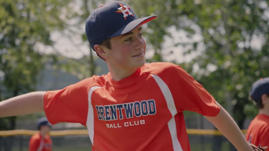 Child catches ball in baseball glove and throws the ball back