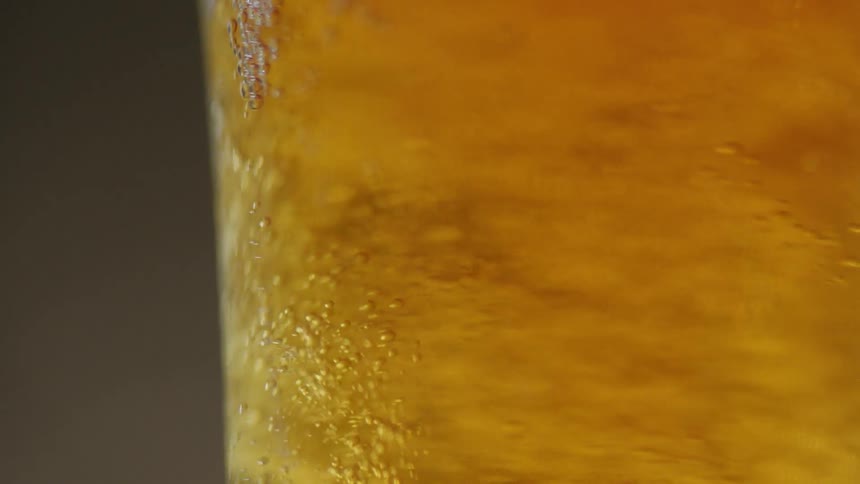 Bubbles are flowing upwards inside a beer