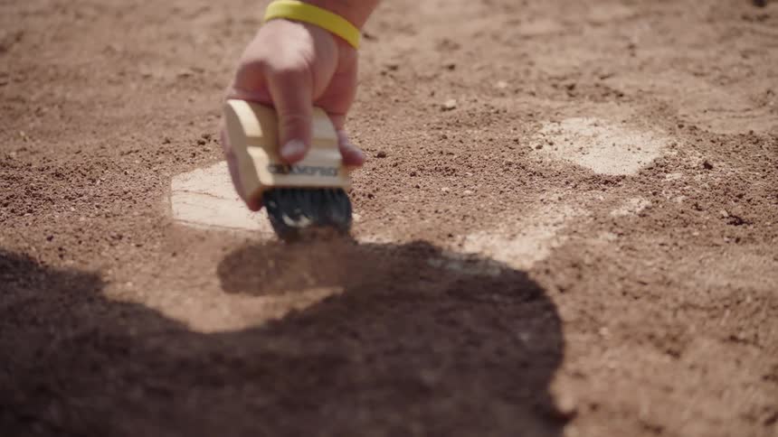 An umpire dusts off home plate
