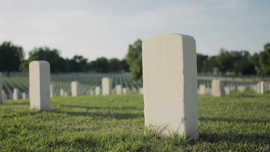 Headstones are lined up in a cemetery