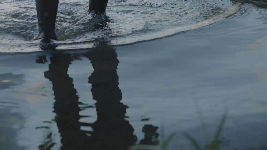 A person walks out of a lake