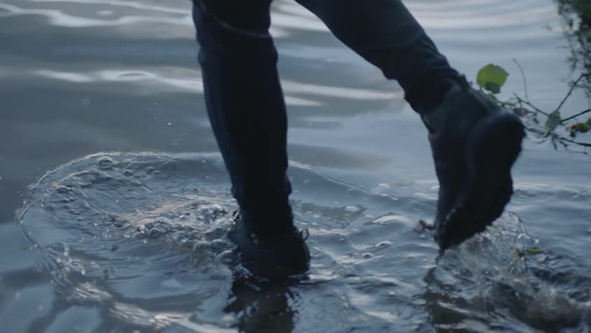 A person walks into a lake