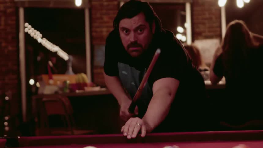Man plays pool in a bar at night