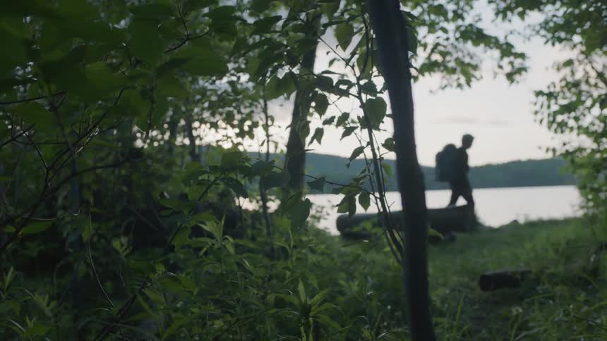 A man hikes along the lakeshore