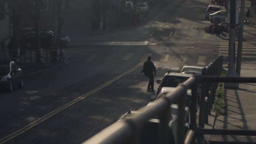 A man rides a skateboard down a city street