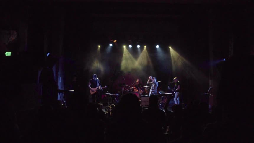 A band is performing in a large room for a group of people