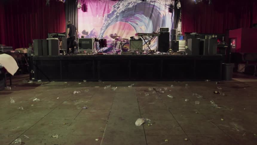 A man sweeps a dirty theater