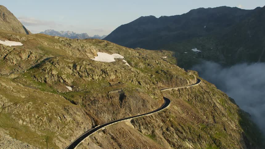 Winding highway road wrapping around the edge of mountain