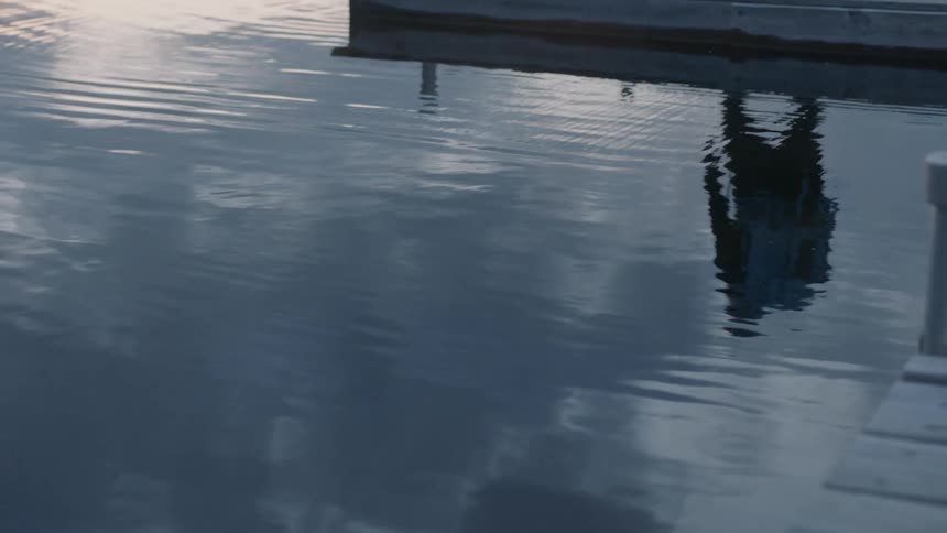 Man walks on a lake dock