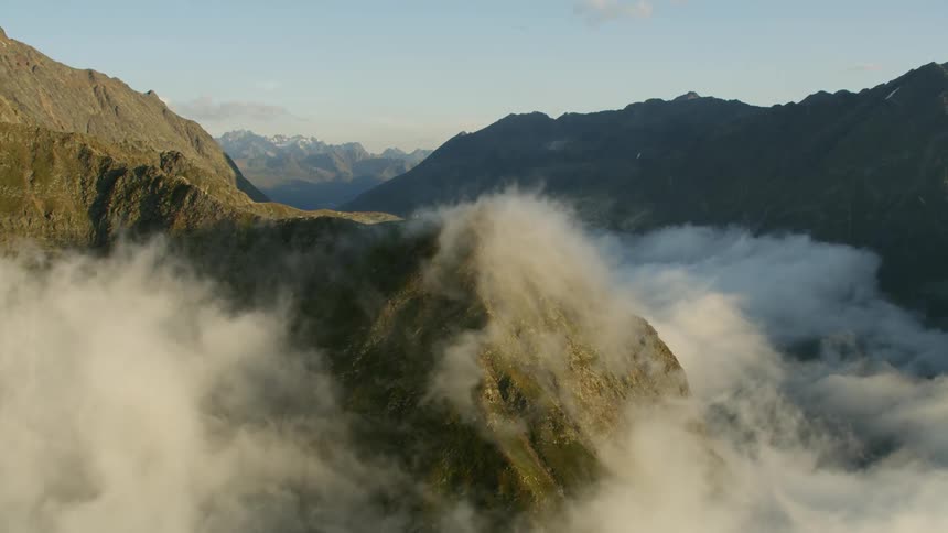 Fog hanging over a valley with mountains rising above it