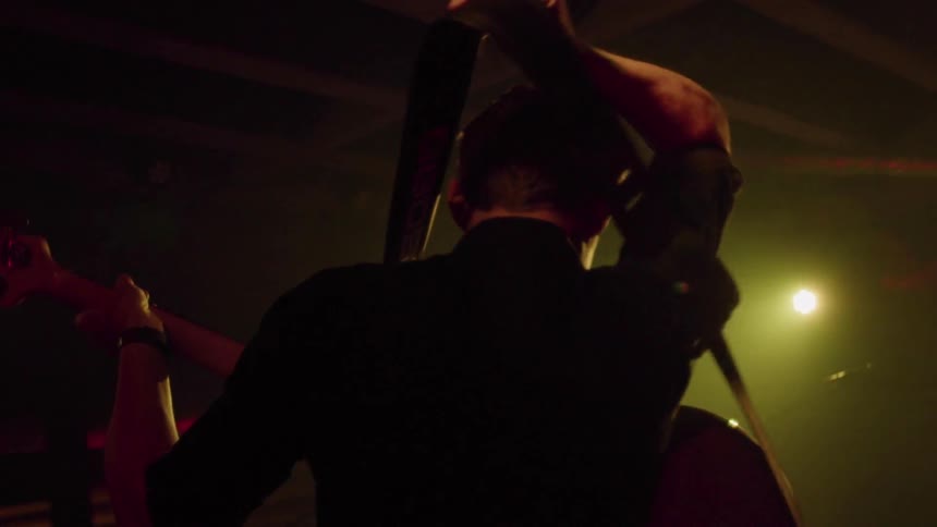 Man lifts a guitar strap over his head