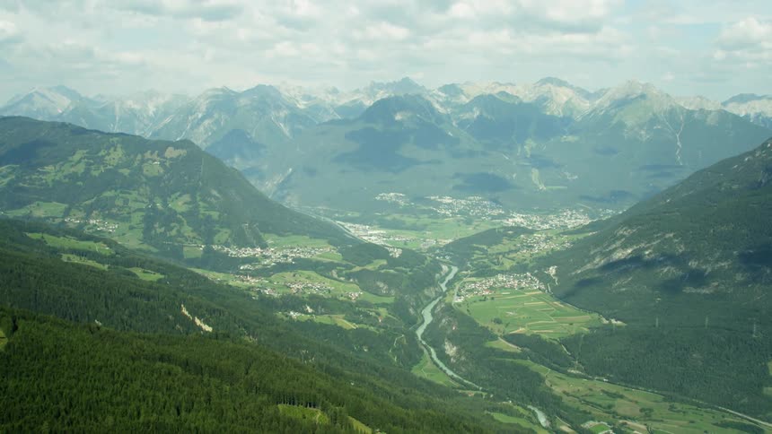 A lush green mountain leads down into a lush green valley