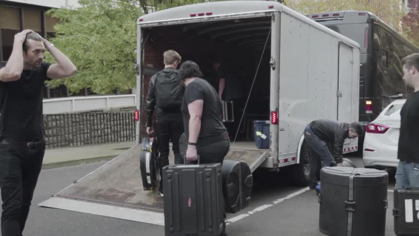 A band moves their equipment into the trailer