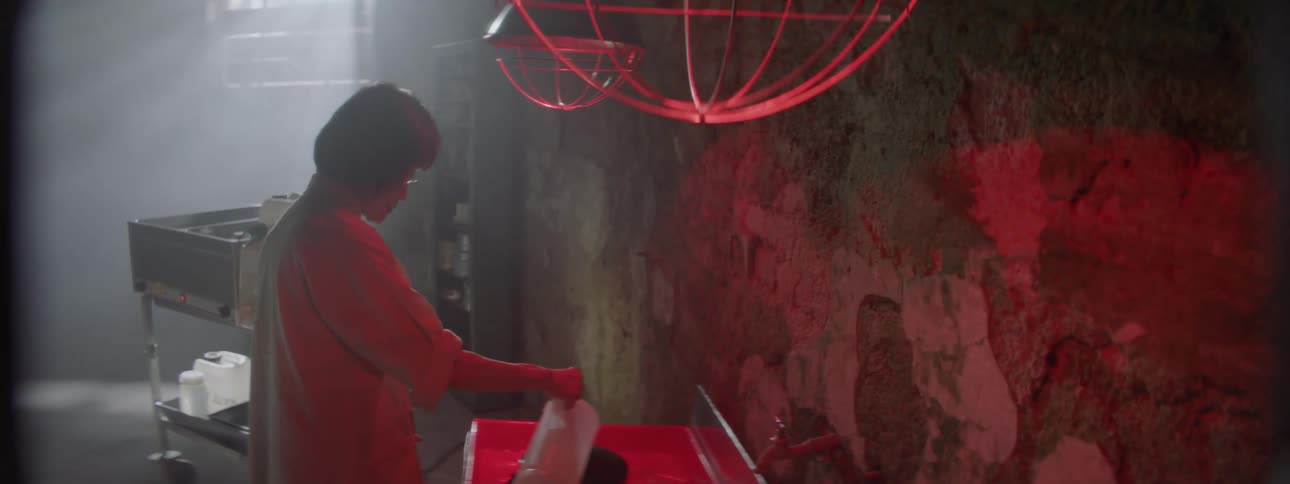 A woman is pouring water into a small pan