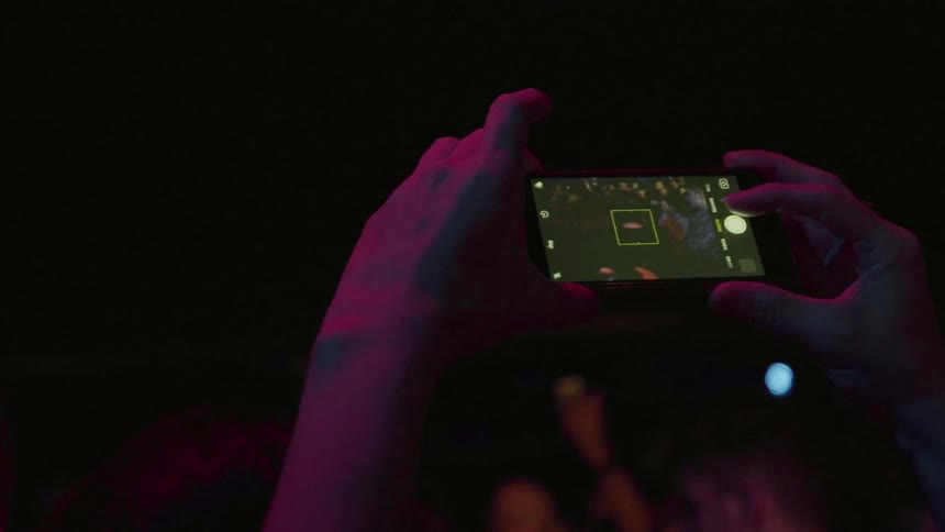 A person takes pictures on their cell phone