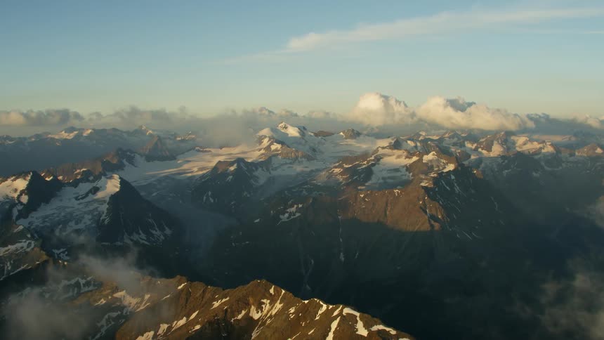 The vast mountain range is topped with clouds and snow